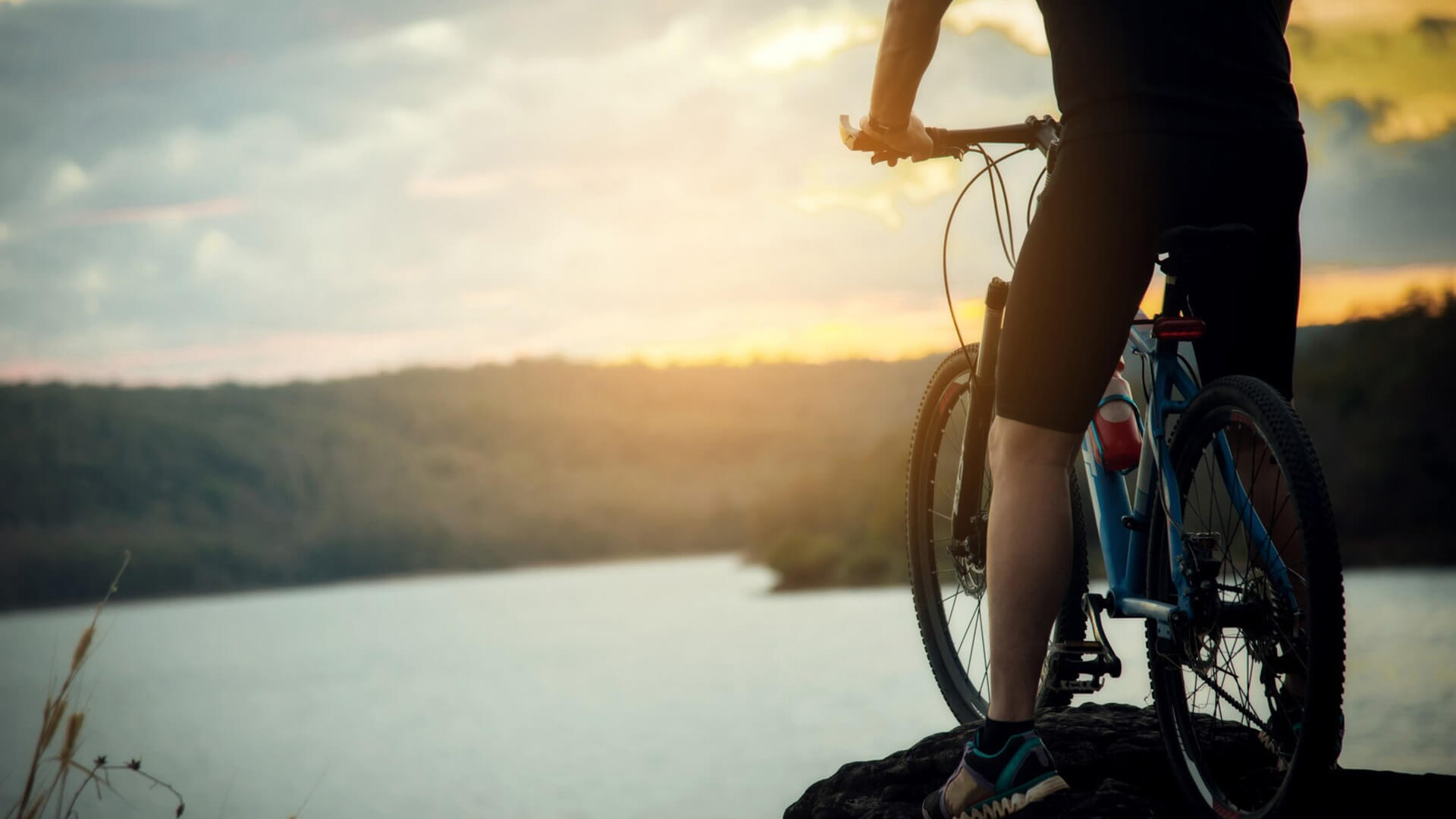 Ciclista con abbigliamento sportivo tecnico INNTEXA e col tramonto
